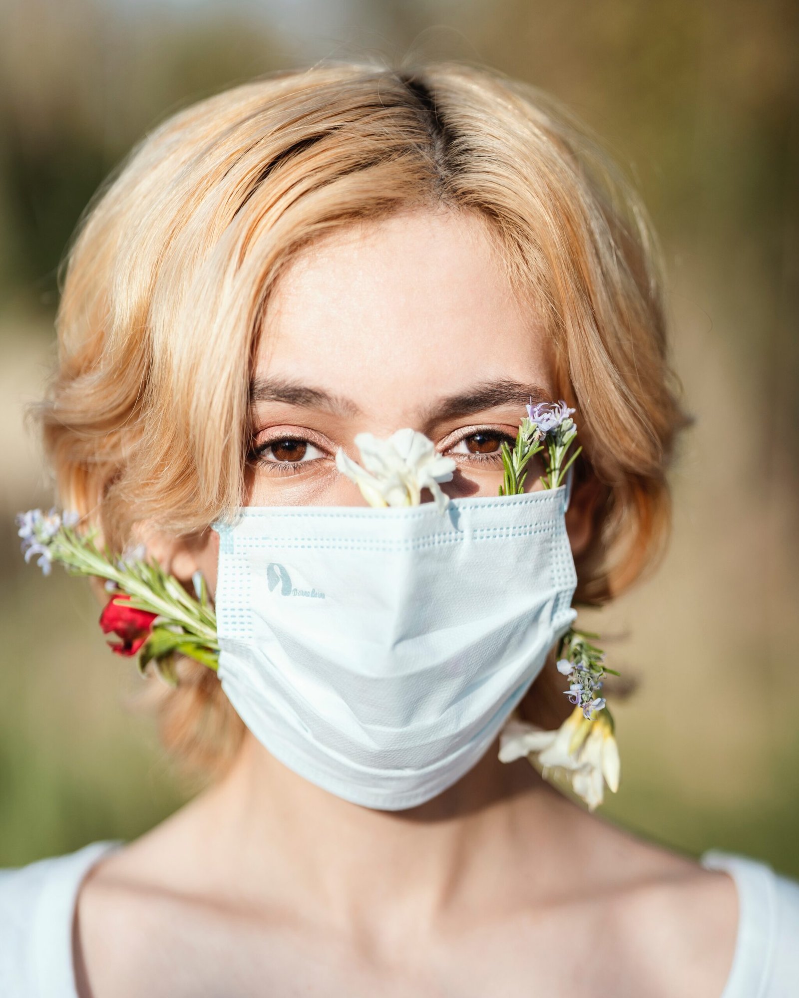 a woman wearing a face mask and flowers in her hair